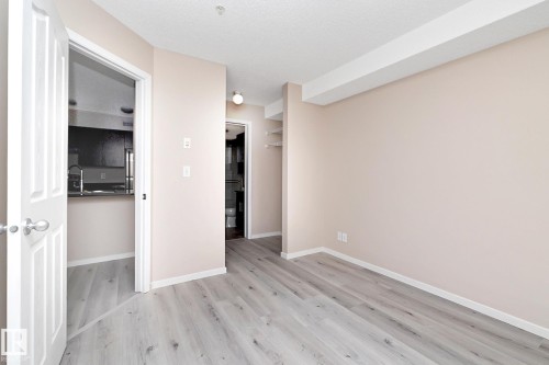 Spacious room with wood-finish flooring and neutral wall tones - 108 530 Watt Boulevard, Edmonton, AB 