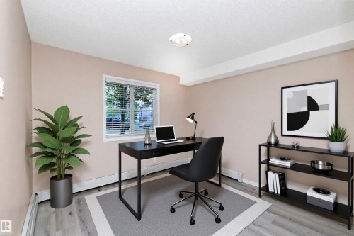Versatile room featuring light-toned wall paint, wood-finish flooring, and a single window with blinds - 108 530 Watt Boulevard, Edmonton, AB 