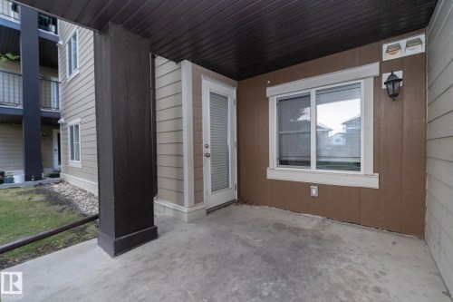 Ground-floor patio featuring a concrete slab, dark wood-finish support column, and beige siding - 108 530 Watt Boulevard, Edmonton, AB 