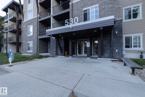 Building exterior featuring stone cladding and horizontal siding - 108 530 Watt Boulevard, Edmonton, AB 