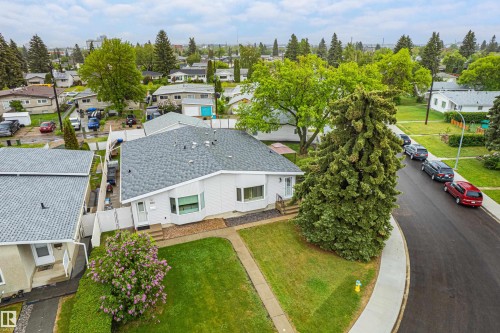 Single-story residence with a gray shingle roof, light-colored siding, and a bay window - 9011 60 Street, Edmonton, AB 