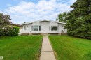 Split-level residence featuring light-colored siding, a front walkway, and a manicured lawn - 9011 60 Street, Edmonton, AB 