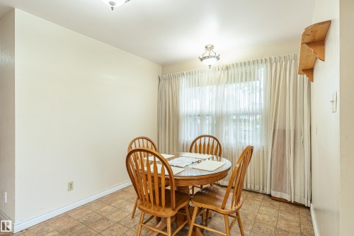 Dining area featuring a window, overhead lighting, and sheet vinyl flooring - 9011 60 Street, Edmonton, AB 