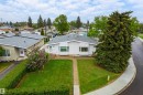 Light-colored exterior with a bay window and a gray shingled roof - 9011 60 Street, Edmonton, AB 