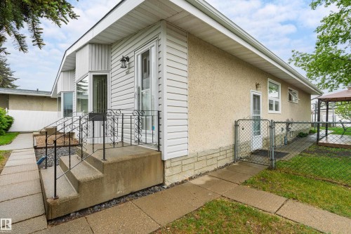 Front exterior featuring white vinyl siding and stucco finishes - 9011 60 Street, Edmonton, AB 
