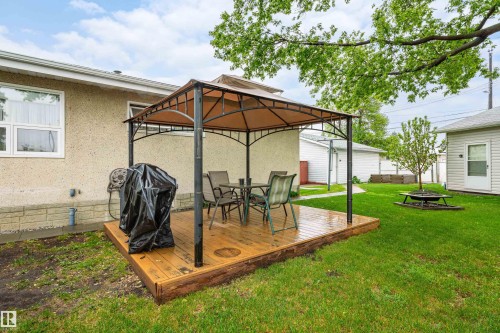 Outdoor wooden deck featuring a gazebo structure, surrounded by a manicured lawn - 9011 60 Street, Edmonton, AB 