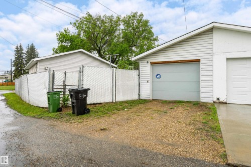 Detached garage structure with white horizontal siding and a light gray garage door - 9011 60 Street, Edmonton, AB 