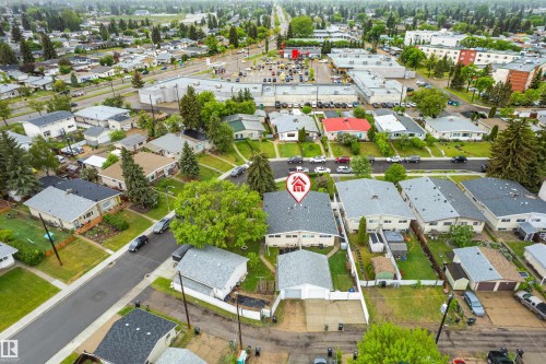 Residential property featuring a detached garage, asphalt driveway, and mature landscaping - 9011 60 Street, Edmonton, AB 
