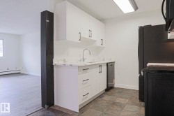 Kitchen featuring white cabinetry, a stainless steel sink with a gooseneck faucet, a dishwasher, and black appliances - 