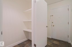 Built-in shelving for organized storage, complemented by a slate-style tile floor and a solid white entry door - 