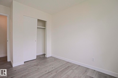 Interior room featuring light-toned walls, wood-finish flooring, and white baseboards - 205 14903 92 Avenue Nw, Edmonton, AB 