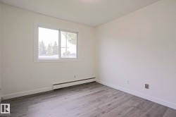 Interior room featuring light gray wood-finish flooring, white baseboards, and neutral wall tones - 