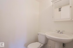 Pedestal sink with chrome faucet, toilet, and mirrored medicine cabinet - 