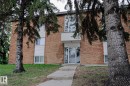 Brick exterior building featuring multiple windows and a white-paneled entrance with an awning - 205 14903 92 Avenue Nw, Edmonton, AB 