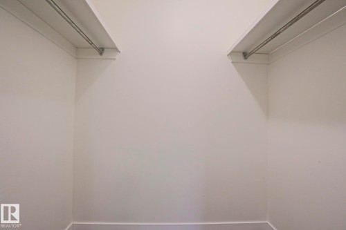 Spacious closet featuring white walls, shelving, and metal hanging rods - 205 14903 92 Avenue Nw, Edmonton, AB 
