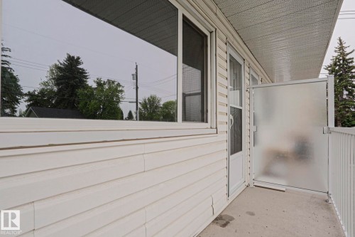 White horizontal siding exterior with a concrete patio - 205 14903 92 Avenue Nw, Edmonton, AB 