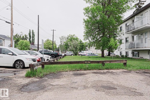 Gravel parking area featuring a wooden barrier with unit numbers - 205 14903 92 Avenue Nw, Edmonton, AB 