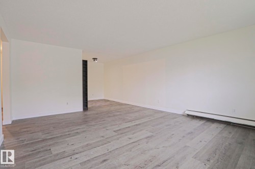Spacious room featuring light wood-finish flooring and neutral wall tones - 205 14903 92 Avenue Nw, Edmonton, AB 