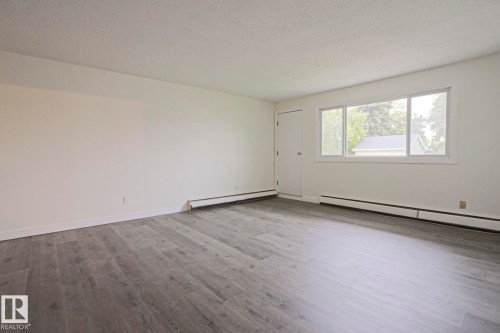Spacious room featuring light gray wood-finish flooring, white walls, and a white ceiling - 205 14903 92 Avenue Nw, Edmonton, AB 