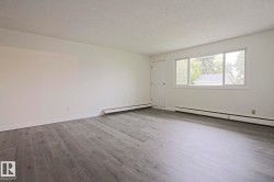 Spacious room featuring light gray wood-finish flooring, white walls, and a white ceiling - 