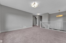 Expansive carpeted area with neutral gray walls and white trim - 