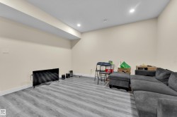 Spacious room featuring light-colored walls, gray wood-finish flooring, recessed lighting, and white baseboards - 