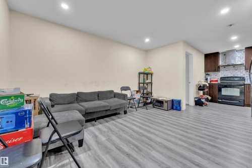 Open-concept living space featuring wood-finish flooring and recessed lighting - 3363 13 Ave, Edmonton, AB 