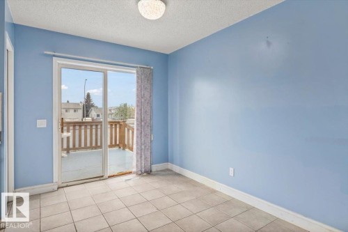 Ceramic tile flooring, sliding glass patio door, and a wooden deck with railing - 8103 154 Avenue, Edmonton, AB 