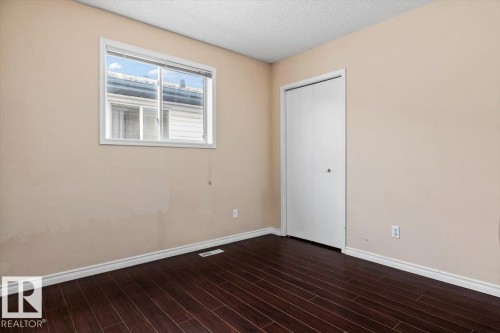 Room featuring dark wood-finish flooring and light-toned walls - 8103 154 Avenue, Edmonton, AB 