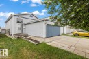 Two-story property featuring light grey siding and a prominent attached garage with a grey door - 8103 154 Avenue, Edmonton, AB 