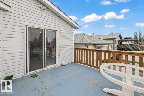 Outdoor deck featuring a wood railing and a sliding glass door entry to the interior - 8103 154 Avenue, Edmonton, AB 