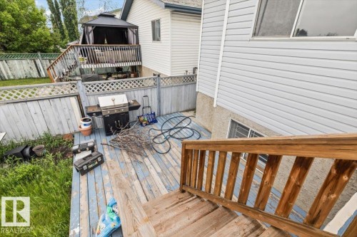 Lower-level deck area featuring a wood railing and a weathered wood-finish surface - 8103 154 Avenue, Edmonton, AB 