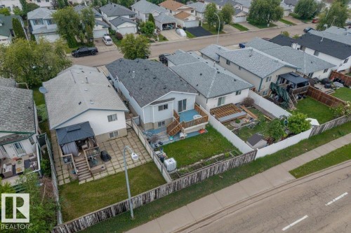 Rear exterior featuring a spacious wooden deck with a gazebo, a concrete patio, and a grassed area - 8103 154 Avenue, Edmonton, AB 