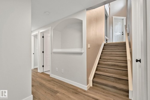 Staircase with wood-finish treads and white risers, featuring a light-toned handrail - 14 53122 Rge Road 14, Rural Parkland County, AB 