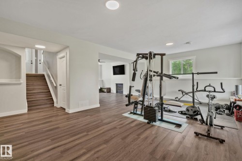 Spacious lower-level room featuring wood-finish flooring, recessed lighting, and a window providing natural illumination - 14 53122 Rge Road 14, Rural Parkland County, AB 