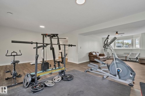 Expansive lower-level room featuring wood-finish flooring, recessed lighting, white walls, and a bay window - 14 53122 Rge Road 14, Rural Parkland County, AB 