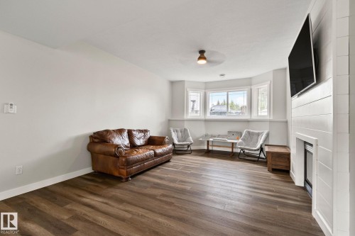 Spacious interior featuring wood-finish flooring, a contemporary ceiling fan, and a bay window - 14 53122 Rge Road 14, Rural Parkland County, AB 