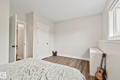 Bright room featuring wood-finish flooring, white trim, and a window with blinds - 14 53122 Rge Road 14, Rural Parkland County, AB 