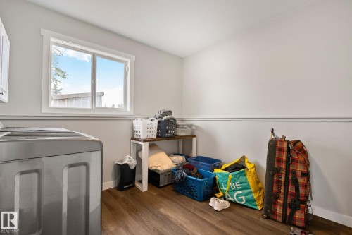 Utility room featuring a window, wood-finish flooring, white walls, and a built-in upper cabinet - 14 53122 Rge Road 14, Rural Parkland County, AB 