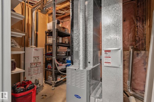 Dedicated utility room featuring a Carrier furnace, water heater, exposed ductwork, and open shelving - 14 53122 Rge Road 14, Rural Parkland County, AB 