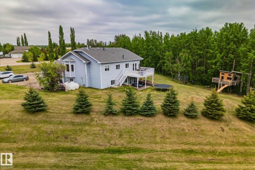 Two-story property featuring light blue siding, a dark shingle roof, and a prominent rear deck with white railings - 14 53122 Rge Road 14, Rural Parkland County, AB 