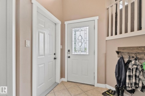 Entryway featuring a decorative glass panel door, durable tiled flooring, and a white baluster railing - 14 53122 Rge Road 14, Rural Parkland County, AB 