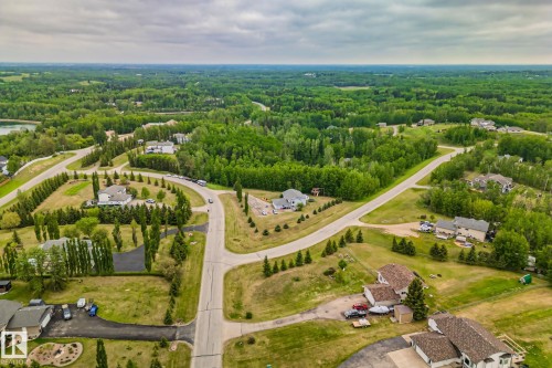 Expansive aerial panorama showcasing a residential development with scattered homes amidst dense, verdant tree lines - 14 53122 Rge Road 14, Rural Parkland County, AB 