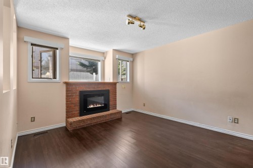 Brick fireplace with a gas insert and a wood mantle - 5 20 Deerbourne Drive, St. Albert, AB 