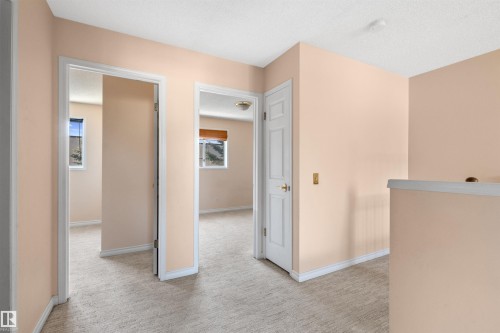 Peach-toned walls with white trim and carpeting throughout - 5 20 Deerbourne Drive, St. Albert, AB 