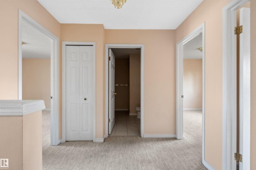 Hallway with light-toned walls and neutral carpet flooring - 5 20 Deerbourne Drive, St. Albert, AB 