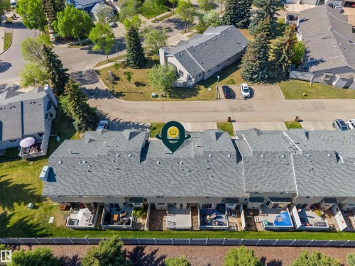 Aerial perspective of a multi-unit residential property featuring grey shingle roofing and individual back patios - 5 20 Deerbourne Drive, St. Albert, AB 