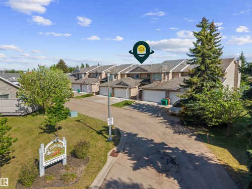 Townhouse exterior featuring an attached garage and individual entry - 5 20 Deerbourne Drive, St. Albert, AB 