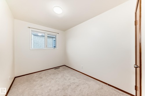 Interior room featuring light-colored carpeting, white wall finishes, and a single window with white trim - 12022 62 Street, Edmonton, AB 