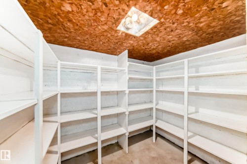 Built-in shelving providing extensive storage capacity, a flush-mount ceiling light fixture, and a textured wood-finish ceiling - 12022 62 Street, Edmonton, AB 